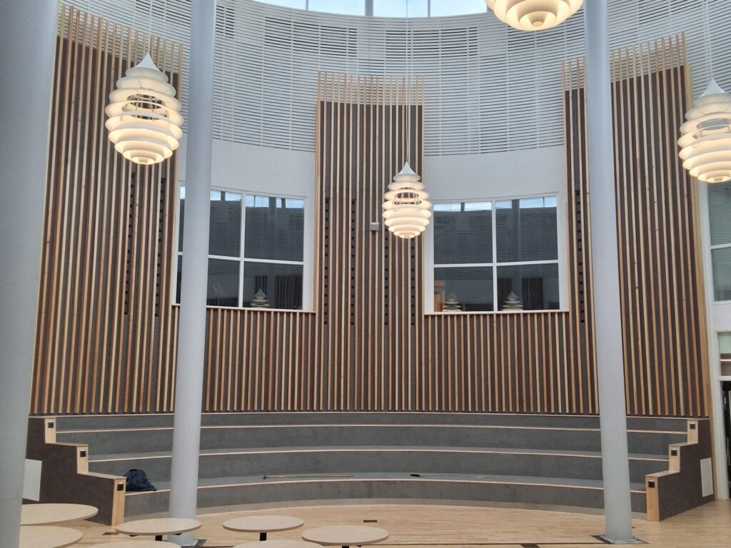 Repus Düsenrohre hinter Holzraster in einem Schulgebäude in Borlänge.